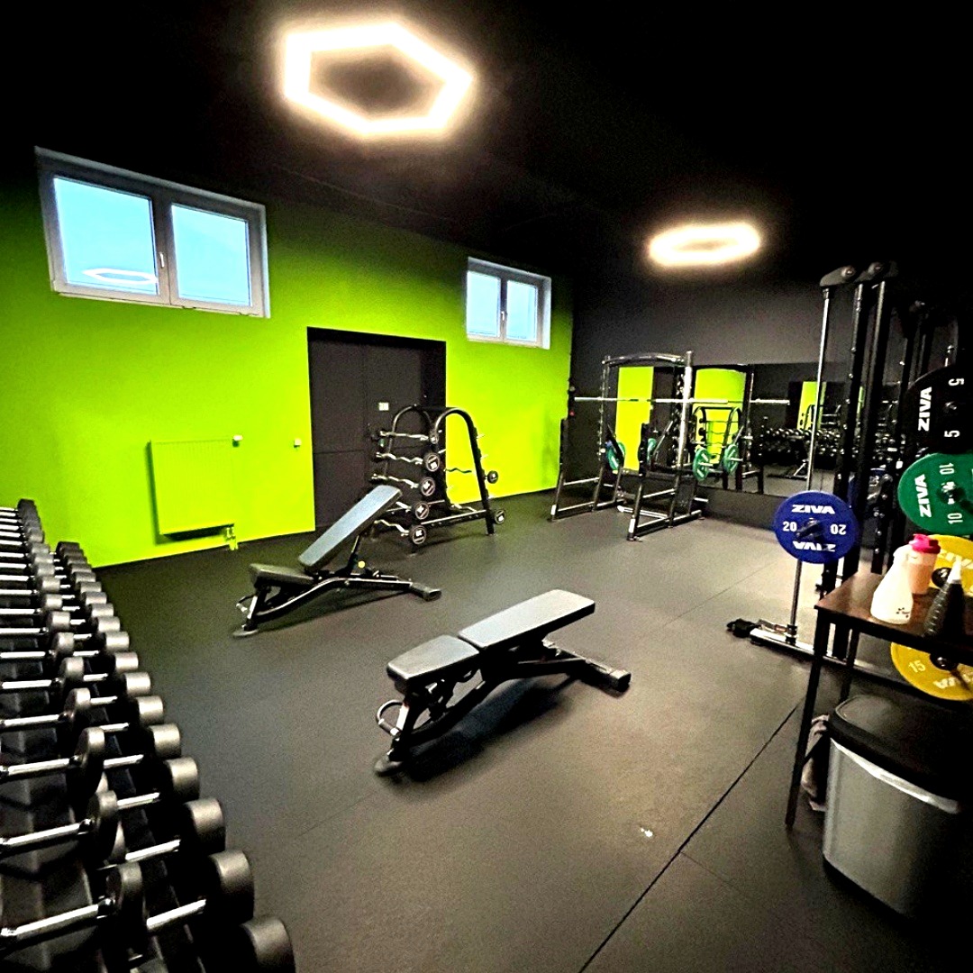 Freihantelbereich mit Kurzhanteln und Langhantel-Stationen